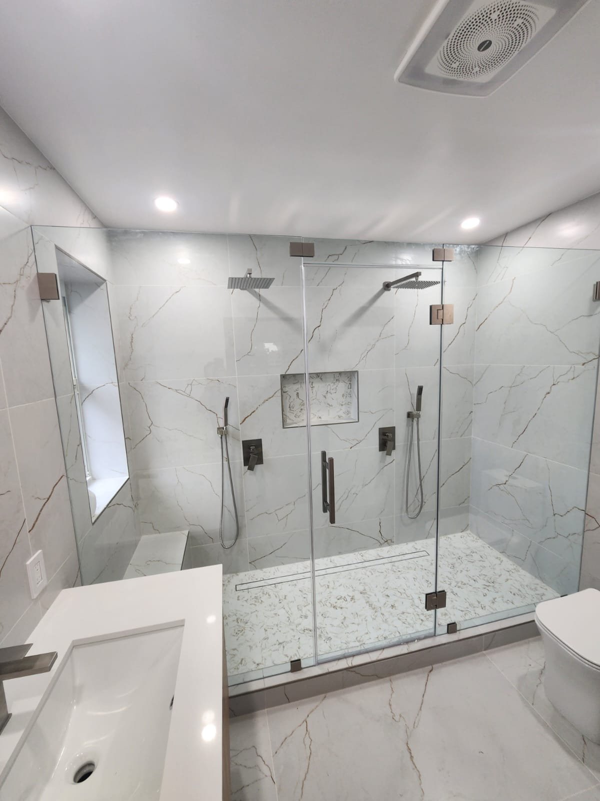 Frameless glass shower with dual rain showerheads