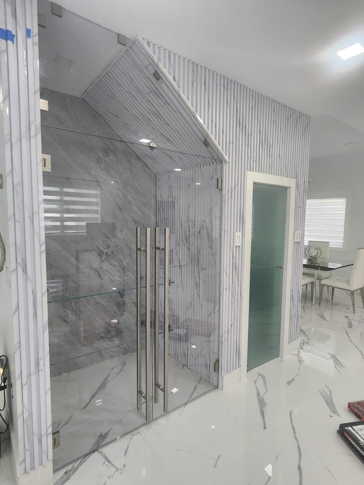 Custom glass-enclosed wine room with frosted glass door